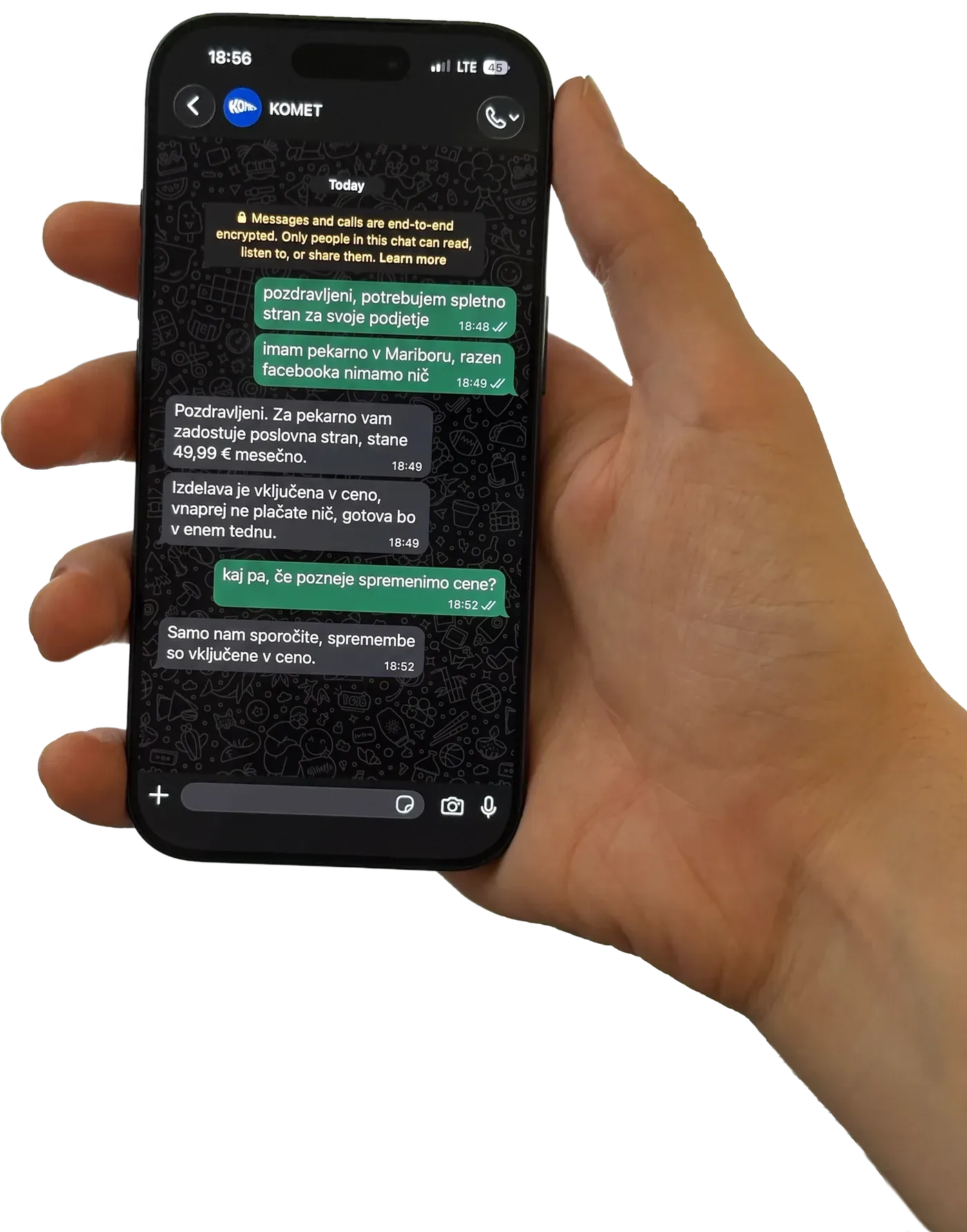 Roka drži telefon z odprtim pogovorom s Kometom o izdelavi spletne strani za pekarno v Mariboru